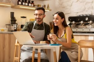 Entrepreneurs drinking coffee and watching video on laptop